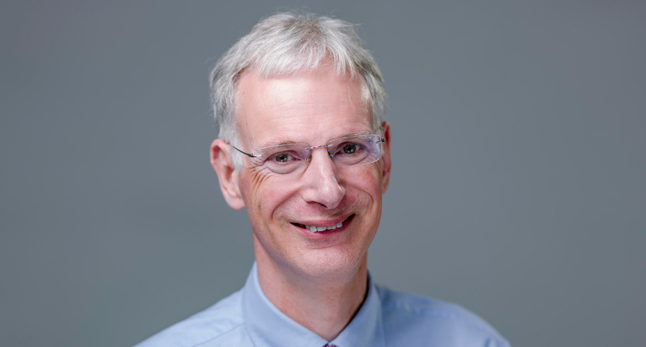 Head and shoulders image of Richard Holland against grey background