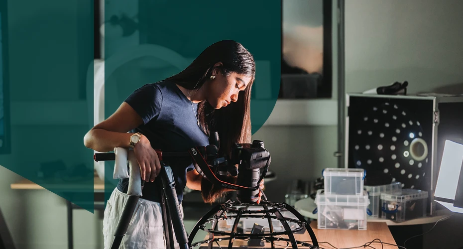 a student looking into a film camera