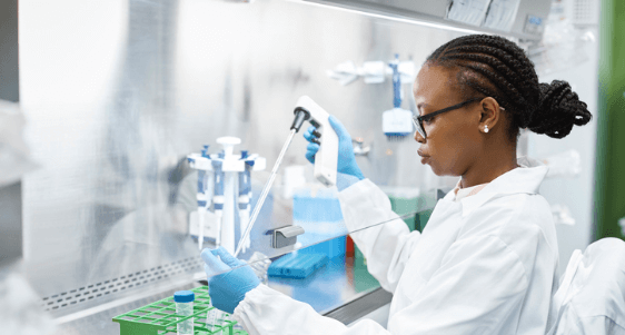 Scientist pipetting in a fume cupboard