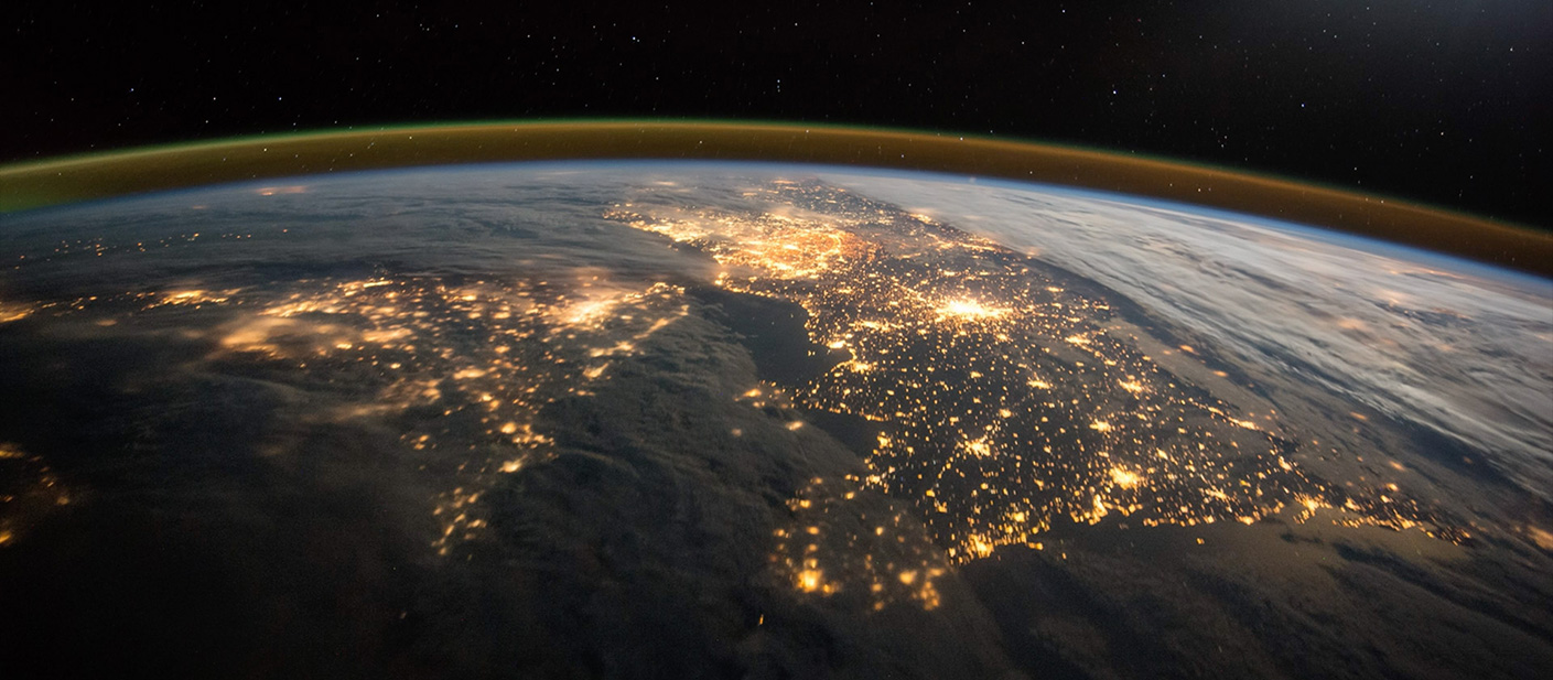 The earch from space, at night, with all the electric lights spanning the continents.