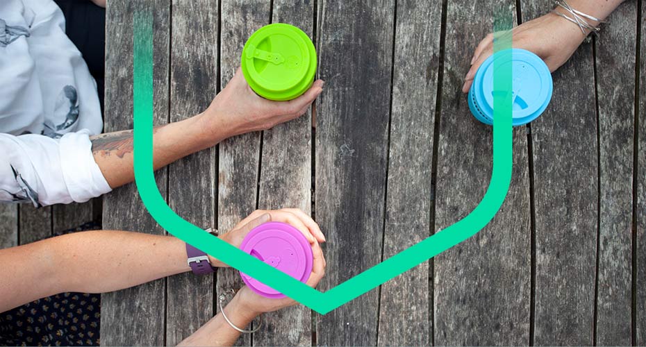 View looking down on three people holding reusable cups