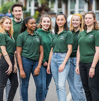 Several individuals wearing green shirts posing for a photo.