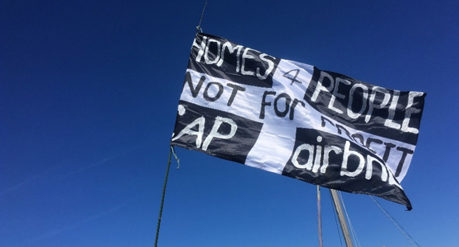 A Cornish flag with the words 'Homes 4 people not for profit - Cap airbnb'